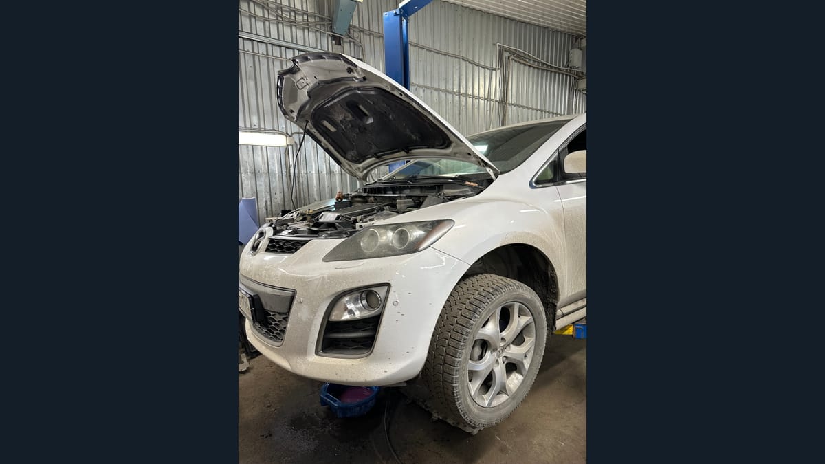 Открытый капот автомобиля на рабочем посту